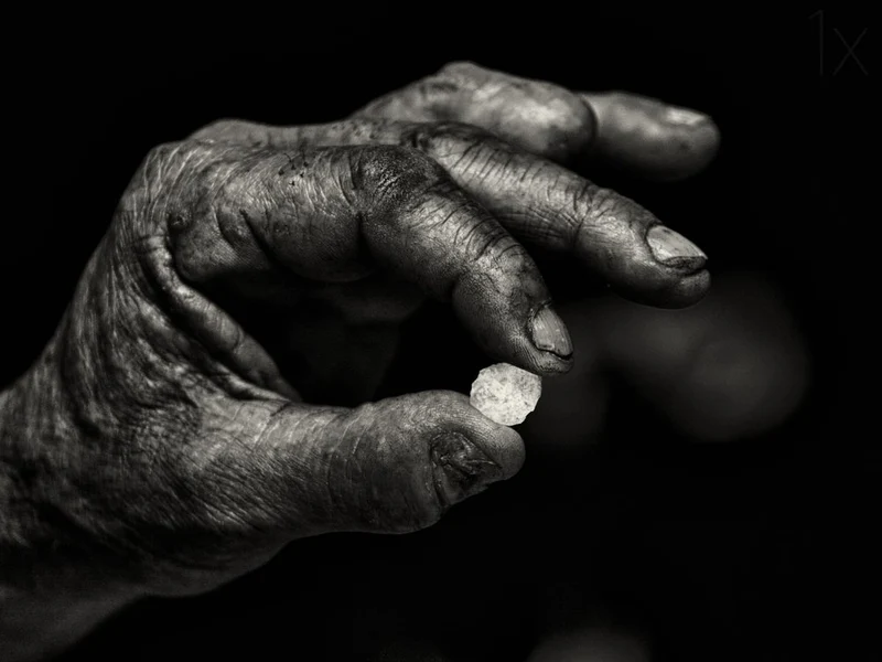 Old Hand Holding Stone