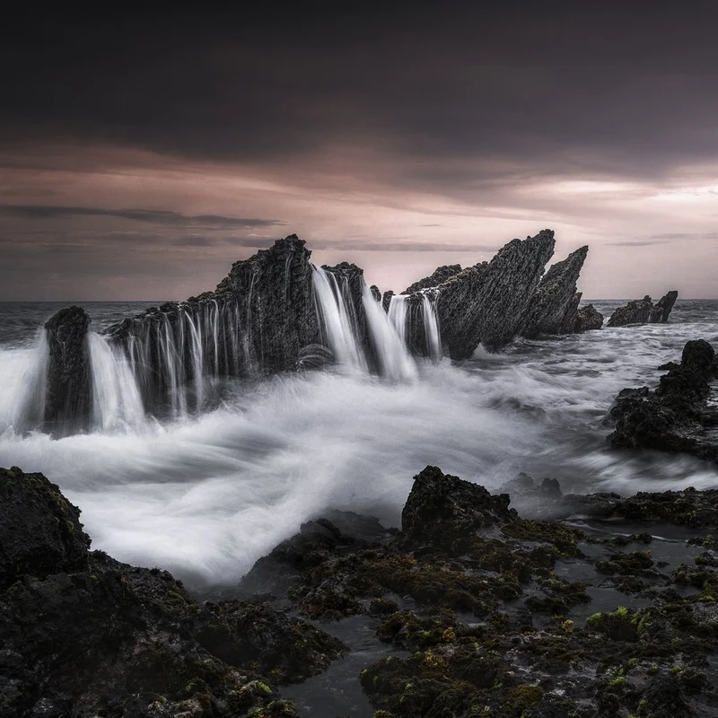 Dark Coastal Waterfall
